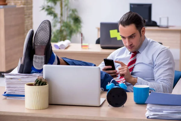 Joven empleado masculino en concepto de gestión del tiempo — Foto de Stock