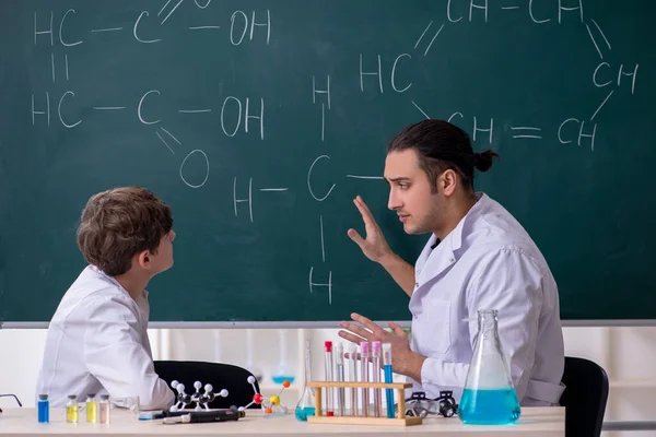 Giovane insegnante di chimica e scolaro in classe — Foto Stock