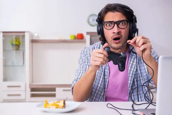 Jovem estudante do sexo masculino jogando jogos de computador em casa — Fotografia de Stock