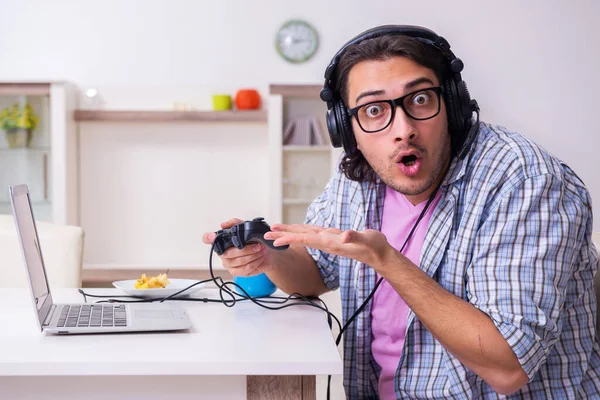 Jeune étudiant masculin jouant à des jeux informatiques à la maison — Photo