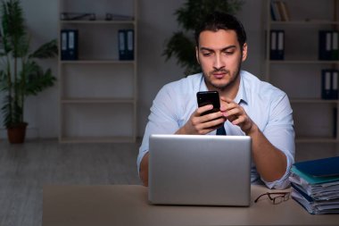 Genç işadamı ofiste geç saatlere kadar çalışıyor.