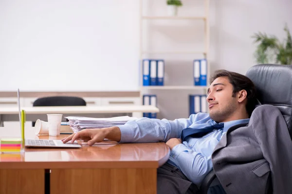 Молодий чоловік співробітник спить в офісі — стокове фото