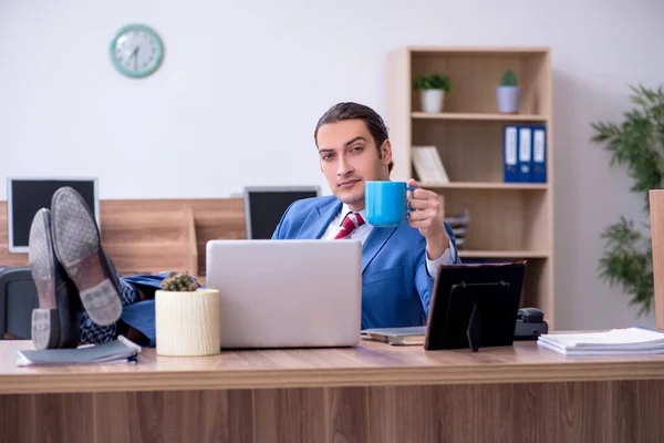 Junge männliche Angestellte trinkt in der Pause Kaffee — Stockfoto