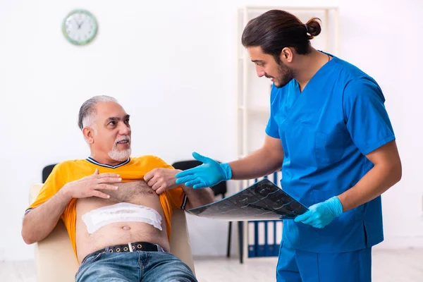 Alt mann besuch jung männlich doktor — Stockfoto