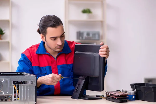 Jovem reparador do sexo masculino reparando computador — Fotografia de Stock