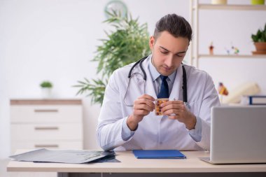 Klinikte çalışan genç erkek doktor.