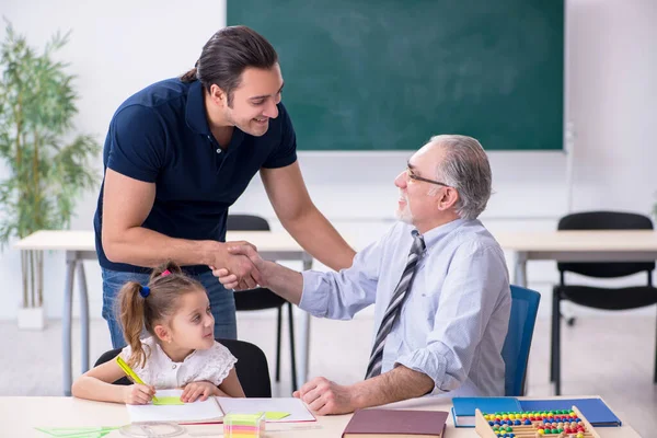 Jonge ouder, oude mannelijke leraar en klein meisje in de klas — Stockfoto