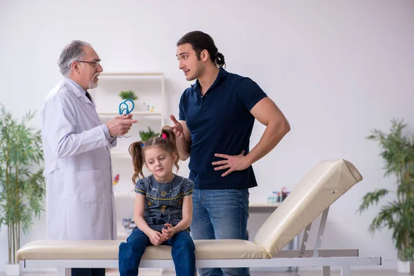 Fiatal apa és lánya meglátogatja az öreg férfi orvost — Stock Fotó