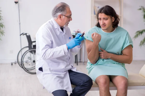 Ung manlig patient besöker erfaren läkare — Stockfoto