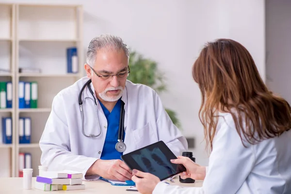 Yaşlı erkek doktor radyoloji uzmanı ve genç bayan asistanı. — Stok fotoğraf