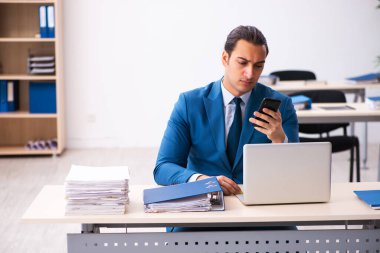 Genç erkek çalışan ofiste oturuyor.