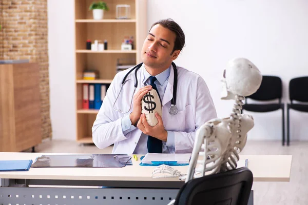 Junger Arzt und Skelettpatient in teurer Medizin — Stockfoto