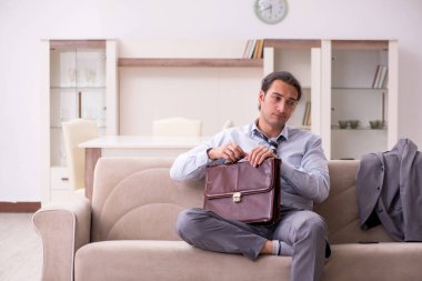 Yorgun genç işadamı işten sonra eve geliyor.