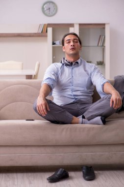 Yorgun genç işadamı işten sonra eve geliyor.