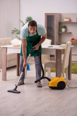 Genç erkek müteahhit evi temizliyor.