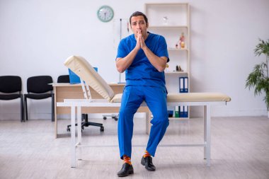 Genç erkek doktor gece vardiyasından sonra mutsuz oluyor.