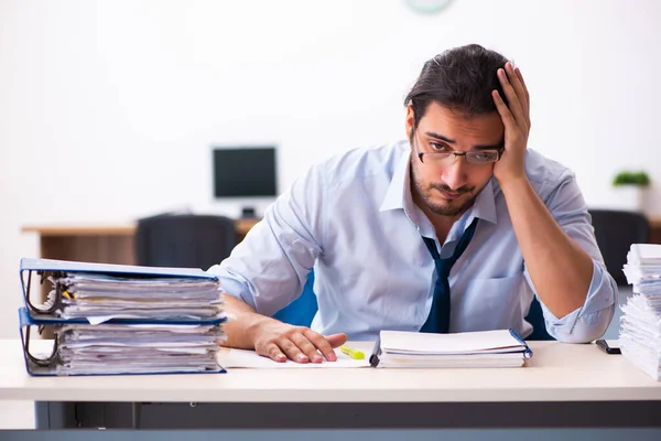 Jovem funcionário masculino infeliz com excesso de trabalho no escritório — Fotografia de Stock