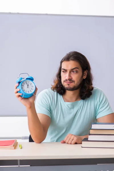 Jonge mannelijke student voorbereiding voor examens in time management concep — Stockfoto