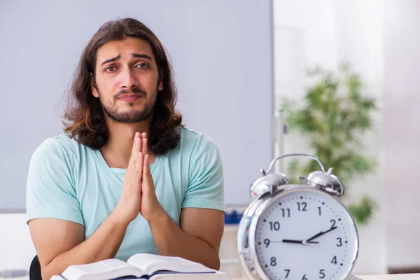 Jonge mannelijke student voorbereiding voor examens in time management concep — Stockfoto