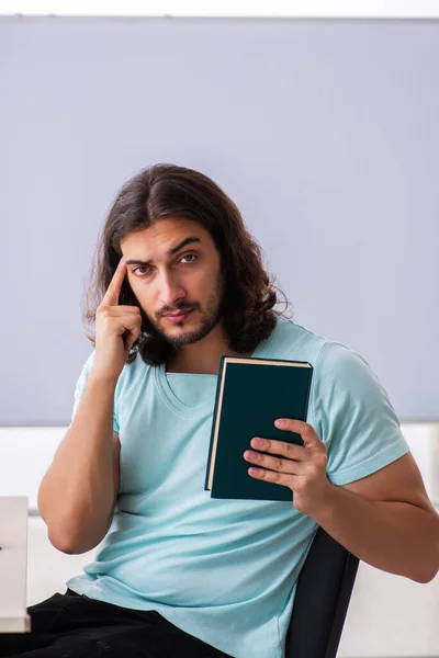 Joven estudiante masculino preparándose para los exámenes en el aula — Foto de Stock