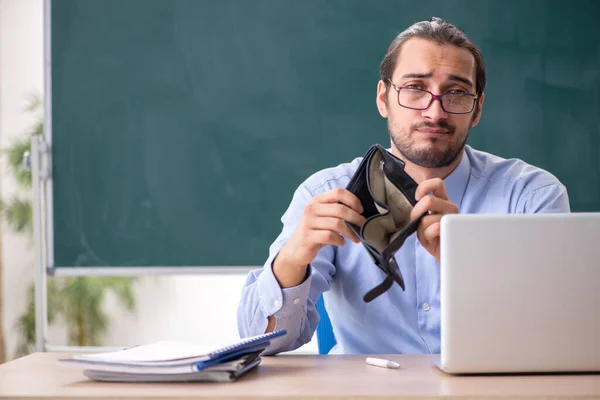 Joven profesor mal pagado en el aula — Foto de Stock