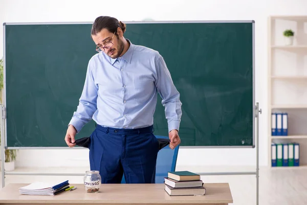 Jonge onderbetaalde mannelijke leraar in de klas — Stockfoto