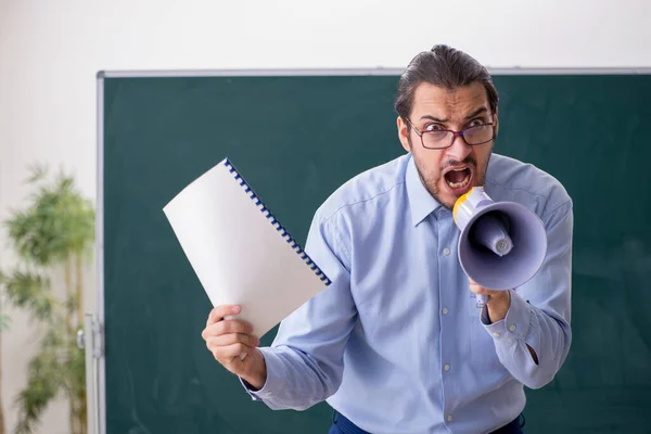 Junger männlicher Lehrer im Klassenzimmer mit Megafon — Stockfoto