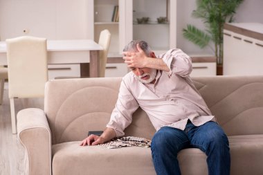 Yaşlı hasta adam evde acı çekiyor.