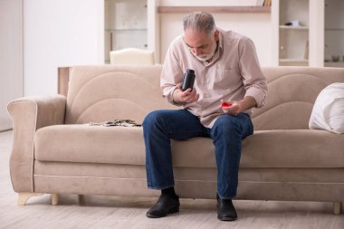 Yaşlı hasta adam evde acı çekiyor.