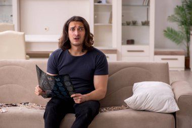 Evde acı çeken genç hasta adam.