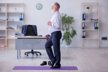 Mola sırasında fiziksel egzersiz yapan yaşlı bir erkek.