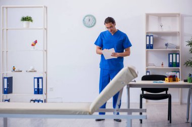 Genç erkek doktor hastanede not alıyor.