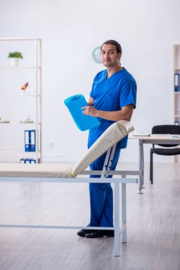 Genç erkek doktor hastanede not alıyor.