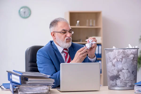 Old businessman employee rejecting new ideas with lots of papers