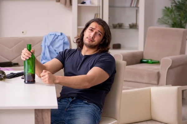 Ung arbetslös man som dricker alkohol hemma — Stockfoto