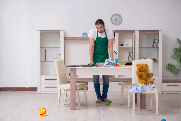 Ung manlig entreprenör städa lägenheten efter barnen fest — Stockfoto