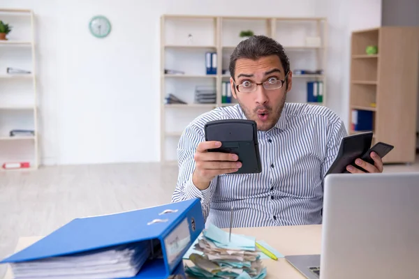 Joven contable masculino calculando los pagos de impuestos en la oficina —  Fotos de Stock