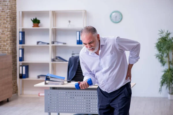 Employé masculin âgé faisant des exercices physiques pendant la pause — Photo