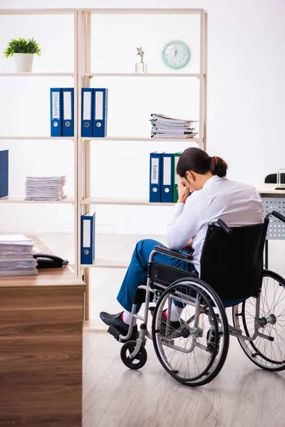 Молодий чоловік після аварії на інвалідному візку на робочому місці — стокове фото
