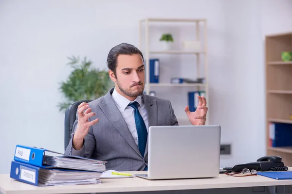 Joven empleado masculino descontento con el trabajo excesivo en la oficina —  Fotos de Stock