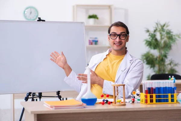 Beyaz tahtanın önünde genç erkek kimyacı öğretmen. — Stok fotoğraf