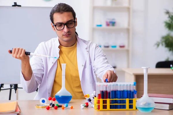 Mladý muž chemik učitel ve třídě — Stock fotografie