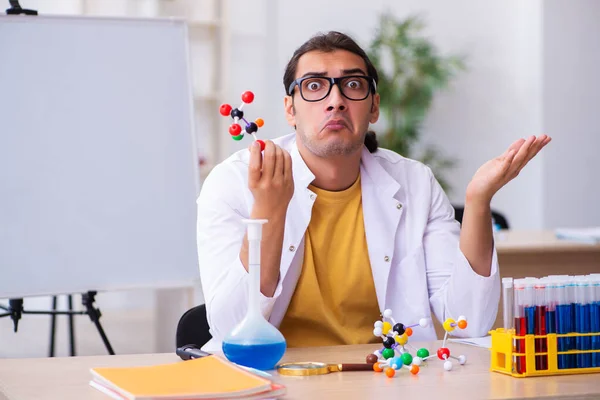 Giovane chimico maschile che studia modello molecolare in classe — Foto Stock
