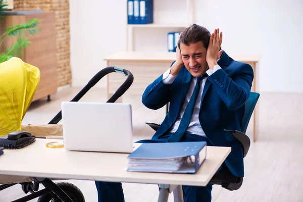 Jonge mannelijke werknemer zorgt voor kind op het werk — Stockfoto