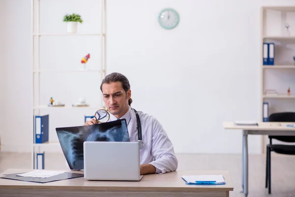 Ung manlig röntgenläkare som arbetar på kliniken — Stockfoto