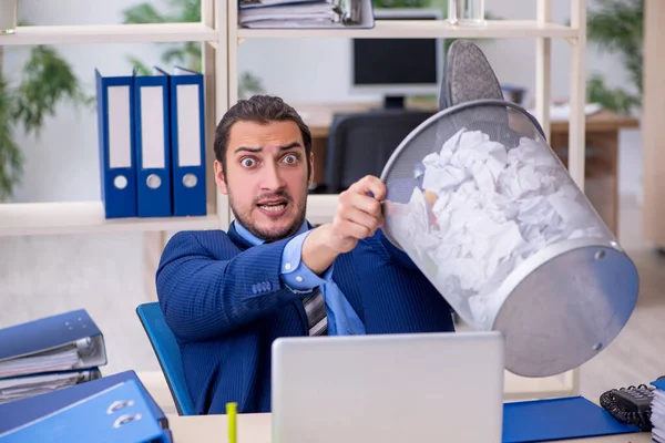 Young businessman employee rejecting new ideas with lots of pape — Stock Photo, Image