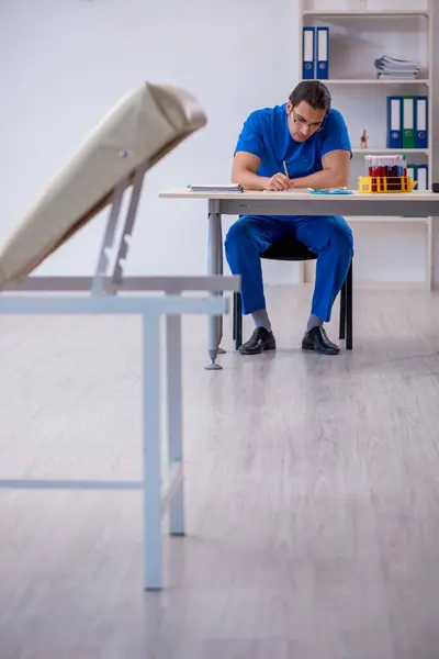 Giovane medico di sesso maschile prendere appunti in ospedale — Foto Stock