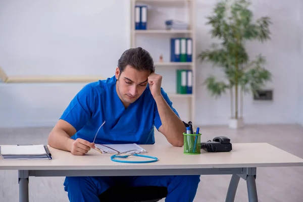 Junger Arzt in der Klinik extrem müde — Stockfoto