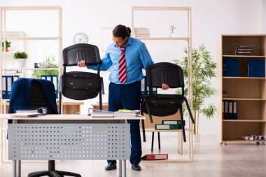 Genç erkek çalışan iş yerinde spor egzersizleri yapıyor.