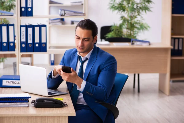 Genç yakışıklı çalışan ofiste oturuyor.